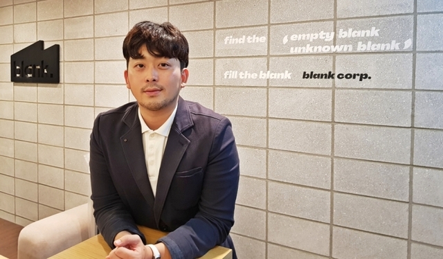 ▲ 임경호 커뮤니케이션 총괄은 ‘고간지’를 제작한 블랭크코퍼레이션을 아티스트와 중소기업을 위한 스타트업이라고 소개했다. 그의 뒤로 블랭크의 캐치프레이즈가 쓰여 있다. “Find the empty blank, unknown blank. fill the blank. blank corp.” “빈 곳을 찾아라, 모르는 빈 곳을 찾아라. 빈 곳을 채워라” 정도로 해석된다. 사진/민현배기자