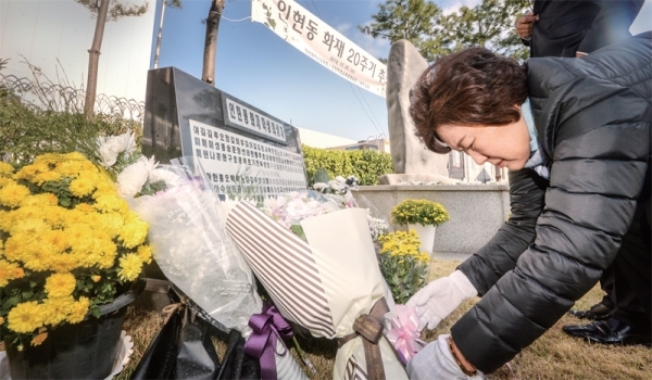 30일 오전 인천 중구 학생문화회관에서 열린 ‘인천 인현동 화재 참사 20주기 추모제’에서 희생 학생의 어머니가 딸의 이름이 새겨진 추모비 앞에 꽃다발을 놓고 있다. 조주현기자