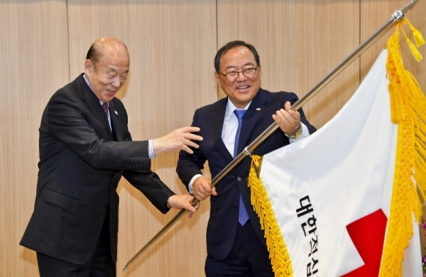 5일 오후 대한적십자사 경기도지사에서 열린 대한적십자사 경기도지사 회장 이취임식에서 박경서 대한적십자사 회장이 김훈동 전임회장에게 적십자기를 이양받아 윤신일 신임회장에게 전달하고 있다. 윤원규기자