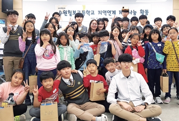 ▲ 수원 칠보고등학교 과학동아리 ‘아두이노’ 학생들이 호매실도서관에서 초등학생들을 위한 다양한 실험체험 프로그램을 운영하는 재능기부 활동후 기념사진을 찍고 있다.