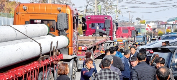 12일 오전 용인시 처인구 양지면 한 물류창고 공사장 앞 도로에서 주민들이 신호등 설치를 반대하는 시위를 벌이고 있다. 한 주민은 “개인 물류창고를 위해 이곳에 신호등을 설치하면 도로가 무척 혼잡해져 주민들이 피해를 볼 것”이라고 주장했다. 윤원규기자