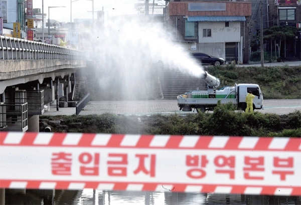 정부가 12일 조류인플루엔자(AI)와 구제역을 막기 위해 철새도래지와 농장에 축산차량 진입을 막고, 구제역 백신 접종을 제대로 하지 않은 농가에 대해서는 최대 농장 폐쇄 조치를 내린다는 내용의 특별방역 조치를 발표했다. 사진은 지난달 27일 H5형 AI 바이러스가 검출된 안성시 일죽면 청미천에서 방역작업을 하고 있는 관계자들. 경기일보DB