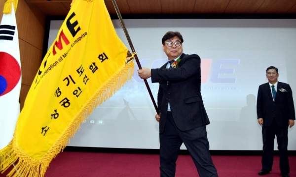 13일 경기지방중소벤처기업청 대강당에서 열린 ‘경기도소상공인연합회 제3기 이상백 회장 취임식 및 2019년 소상공인의 날 기념행사’에서 이상백 경기도소상공인연합회장이 최승재 소상공인연합회장으로 부터 전달받은 연합회기를 흔들고 있다.전형민기자