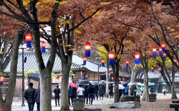 겨울을 재촉하는 비가 내려 기온이 뚝 떨어진 17일 용인 한국민속촌에서 우산을 쓴 관광객들이 낙옆이 쌓인 거리를 걷고 있다.전형민기자