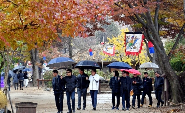 겨울을 재촉하는 비가 내려 기온이 뚝 떨어진 17일 용인 한국민속촌에서 우산을 쓴 관광객들이 낙옆이 쌓인 거리를 걷고 있다.전형민기자
