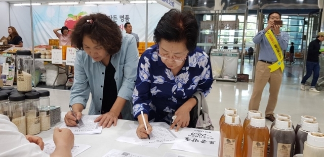▲ 지난해 9월 서울 서초구 양재동 aT 센터에서 진행된 ‘2018 경기도 로컬푸드 농축산물 대축제’에서 홍보부스를 찾은 관람객들이 로컬푸드 관련 설문조사에 응하고 있다