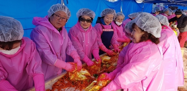 이금자 경기도여성단체협의회장과 박재근 경기도자원봉사센터 이사장을 비롯한 참가자들이 소외계층에 전달할 김치를 담고 있다.