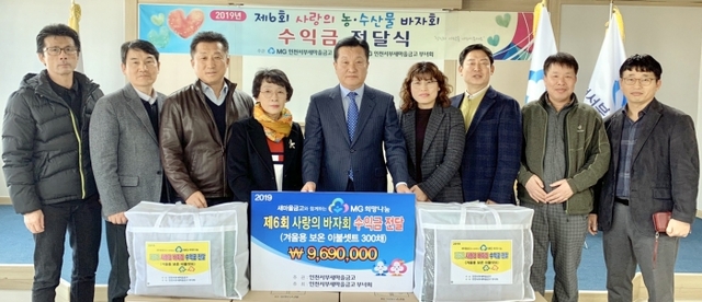 윤의상(오른쪽 5번째) 인천 서부새마을금고 이사장, 박경담 부년회장 등 서구 7개동 행복복지센터 동장들이 물품 전달에 앞서 기념촬영하고 있다.
