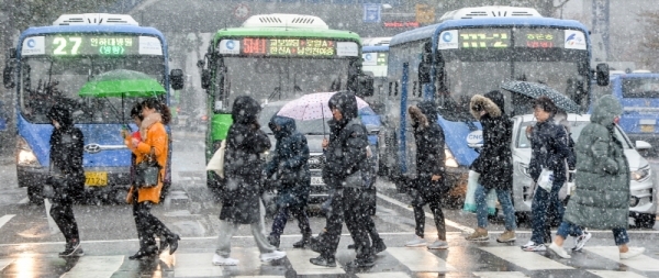 인천지역에 첫눈이 내린 3일 오전 인천 미추홀구 터미널사거리에서 시민이 발걸음을 재촉하고 있다.조주현기자