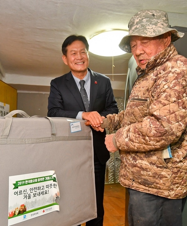 6일 오후 안산 시내 일원에서 열린 '2019 마사회 따뜻한 겨울나기 지원사업'에서 김종길 마사회 부회장이 독거노인에게 혹한기 난방용품을 지원하고 있다. 윤원규 기자