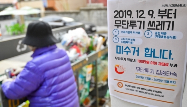 9일 오후 부천시 한 주택가에 무단투기 쓰레기 미수거를 알리는 안내문 너머로 일반 비닐봉투에 담겨 버려진 쓰레기가 쌓여있다. 수도권매립지는 종량제 봉투 미사용, 재활용품과 음식물쓰레기를 일반쓰레기와 섞는 등 무단투기 생활폐기물이 전체 폐기물의 15%를 초과하면 반입을 규제하는데 부천시는 지난 10월,11월에 15%를 초과해 9일부터 무단투기 쓰레기 미수거란 대책을 내놓았다. 윤원규 기자