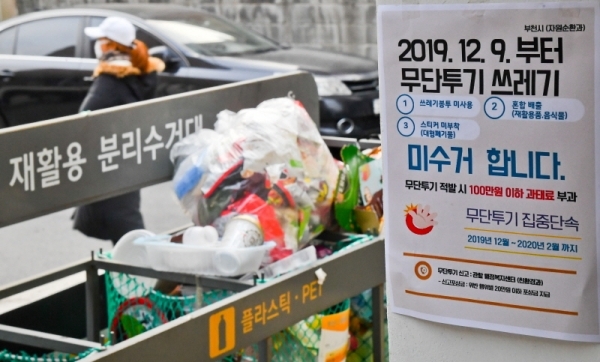 9일 오후 부천시 한 주택가에 무단투기 쓰레기 미수거를 알리는 안내문 너머로 일반 비닐봉투에 담겨 버려진 쓰레기가 쌓여있다. 수도권매립지는 종량제 봉투 미사용, 재활용품과 음식물쓰레기를 일반쓰레기와 섞는 등 무단투기 생활폐기물이 전체 폐기물의 15%를 초과하면 반입을 규제하는데 부천시는 지난 10월,11월에 15%를 초과해 9일부터 무단투기 쓰레기 미수거란 대책을 내놓았다. 윤원규 기자