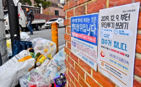 9일 오후 부천시 한 주택가에 무단투기 쓰레기 미수거를 알리는 안내문 너머로 일반 비닐봉투에 담겨 버려진 쓰레기가 쌓여있다. 수도권매립지는 종량제 봉투 미사용, 재활용품과 음식물쓰레기를 일반쓰레기와 섞는 등 무단투기 생활폐기물이 전체 폐기물의 15%를 초과하면 반입을 규제하는데 부천시는 지난 10월,11월에 15%를 초과해 9일부터 무단투기 쓰레기 미수거란 대책을 내놓았다. 윤원규 기자