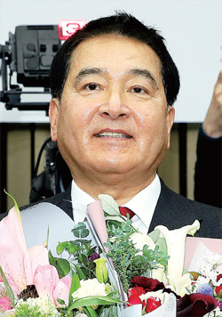 자유한국당 새 원내대표에 선출된 심재철 의원이 9일 국회에서 열린 의원총회에서 축하 꽃다발을 받고 기뻐하고 있다. 연합뉴스