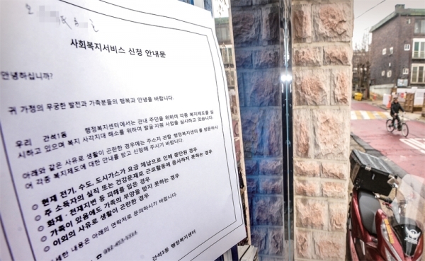 17일 오전 인천 남동구 간석동 한 공동주택 현관 입구에 저소득층 주민지원사업 대상자의 호수와 이름 일부(점선 내)가 적힌 안내문이 버젓이 붙어 있다. 조주현기자