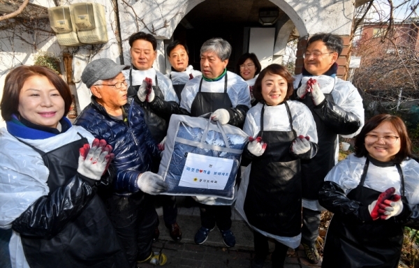 '경기도의회 사랑의 연탄나눔 행사'가 열린 18일 오전 수원시 장안구 주택가에서 도의회 송한준 의장, 안혜영 부의장, 장현국·김직란·김은주·최종현·이애형·민경선의원이 이불을 건네고 기념촬영을 하고 있다. 경기도의회는 수원, 용인에서 각각 3가구씩 총 6세대를 대상으로 연탄 1800장을 전달했다.윤원규기자