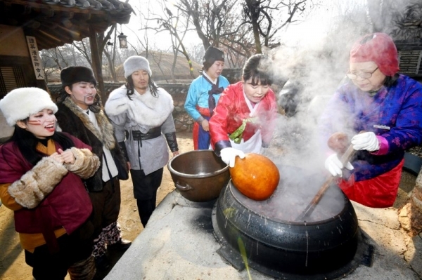 밤이 가장 길고 낮이 가장 짧은 절기상 동지(冬至)인 22일 용인 한국민속촌에서 열린 세시풍속 체험행사에서 한국민속촌 관계자들이 전통방식으로 가마솥에 동지팥죽을 쑤고 있다.전형민기자