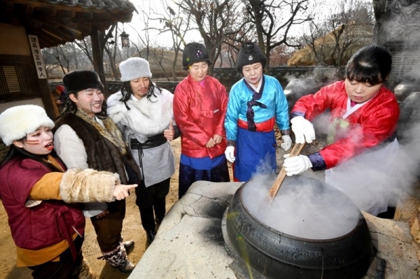 밤이 가장 길고 낮이 가장 짧은 절기상 동지(冬至)인 22일 용인 한국민속촌에서 열린 세시풍속 체험행사에서 한국민속촌 관계자들이 전통방식으로 가마솥에 동지팥죽을 쑤고 있다.전형민기자