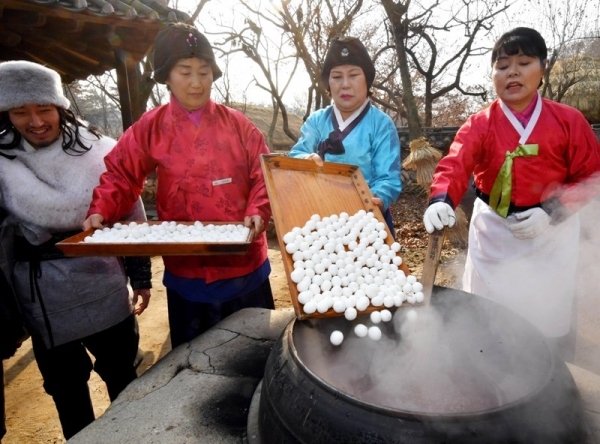 밤이 가장 길고 낮이 가장 짧은 절기상 동지(冬至)인 22일 용인 한국민속촌에서 열린 세시풍속 체험행사에서 한국민속촌 관계자들이 전통방식으로 가마솥에 동지팥죽을 쑤고 있다.전형민기자