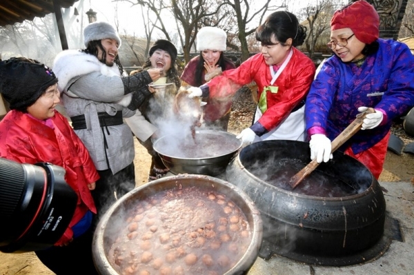 밤이 가장 길고 낮이 가장 짧은 절기상 동지(冬至)인 22일 용인 한국민속촌에서 열린 세시풍속 체험행사에서 한국민속촌 관계자들이 전통방식으로 가마솥에 동지팥죽을 쑤고 있다.전형민기자