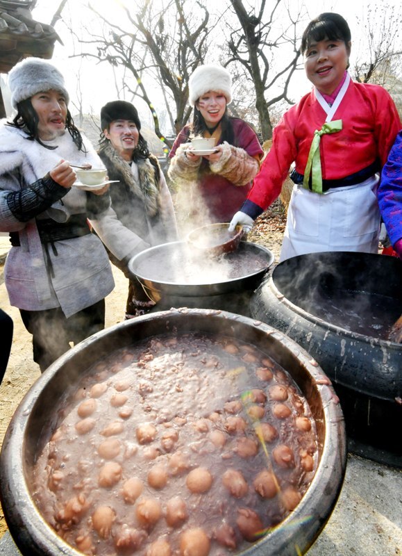 밤이 가장 길고 낮이 가장 짧은 절기상 동지(冬至)인 22일 용인 한국민속촌에서 열린 세시풍속 체험행사에서 한국민속촌 관계자들이 전통방식으로 가마솥에 동지팥죽을 쑤고 있다.전형민기자