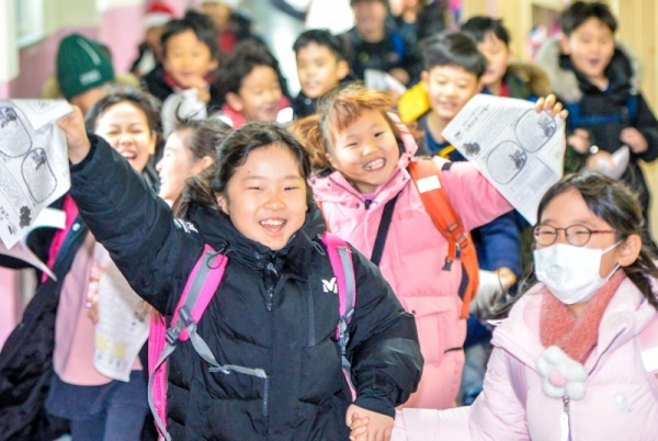 23일 겨울방학을 맞은 인천 계양구 부현초등학교 어린이들이 방학계획서를 들고 즐거운 표정으로 뛰어 나오고 있다.조주현기자