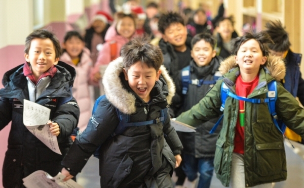 23일 겨울방학을 맞은 인천 계양구 부현초등학교 어린이들이 방학계획서를 들고 즐거운 표정으로 뛰어 나오고 있다.조주현기자