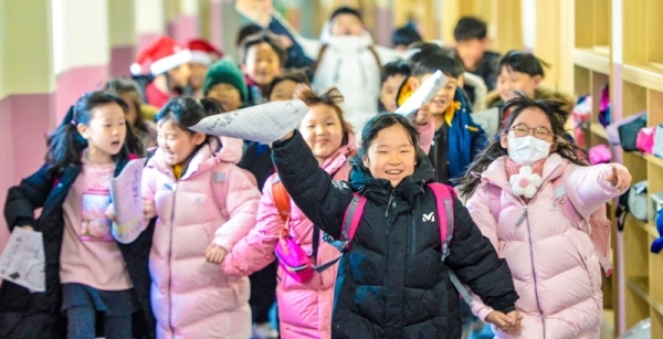 23일 겨울방학을 맞은 인천 계양구 부현초등학교 어린이들이 방학계획서를 들고 즐거운 표정으로 뛰어 나오고 있다.조주현기자