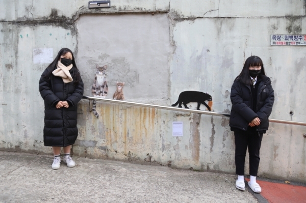 붕어빵 포장마차 앞에 붕어빵을 기다리는 고양이 가족을 그려 설치. 사진 우성고 제공
