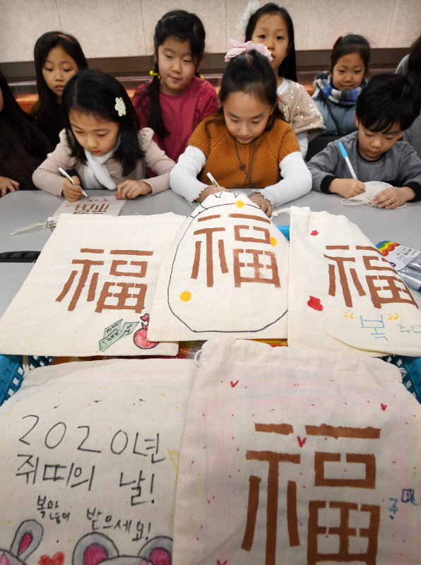 '열두 띠 동물 복 주머니 만들기' 행사가 열린 14일 오후 용인시 박물관 다목적홀에서 겨울방학을 맞은 초등학생들이 에코백을 이용해 다양한 복주머니를 만들고 있다. 김시범기자