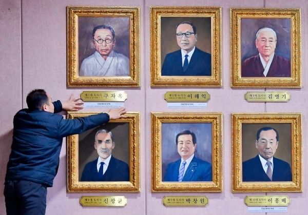 14일 오후 경기도청 신관 4층 대회의실에서 관계자가 역대 도지사 액자 중 중 친일인명사전에 등재된 1대 · 2대 · 6대 · 10대 도지사의 액자 밑에 친일 행적 내용을 부착하고 있다. 윤원규기자