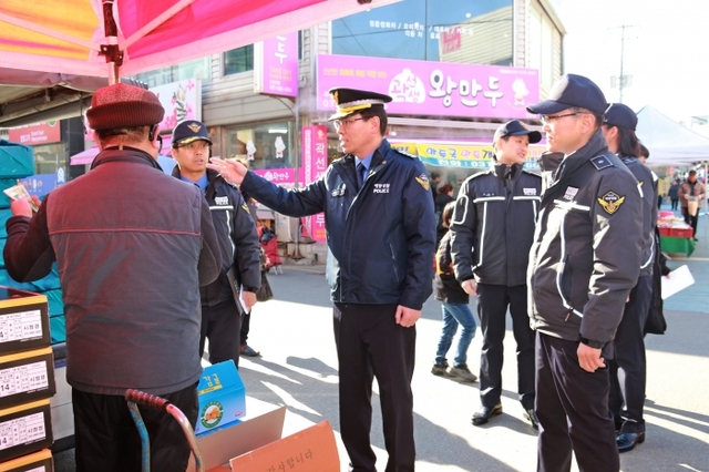 안중시장을 방문한 김석진 평택해양경찰서장이 과일을 구입하고 있다. 평택해경 제공