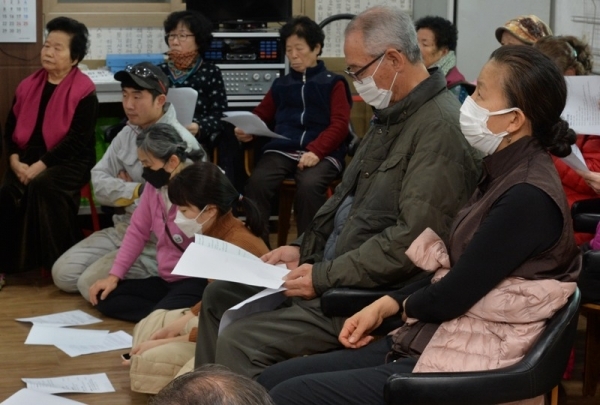 경기도 화성시 향남읍 한 자원재활용업체에서 발생한 화재 진화 작업이 이틀째 계속되면서 마을 주민들이 매캐한 냄새로 인한 고통을 호소하고 있다. 23일 오후 구문천 3리 마을회관에서 마스크를 착용한 마을 주민들이 화성시와 소방관계자의 브리핑을 듣고 있다.조주현기자