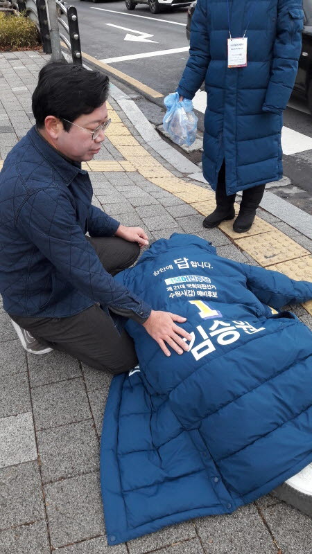 쓰러진 행인에게 응급조치를 실시하는 김승원 예비후보