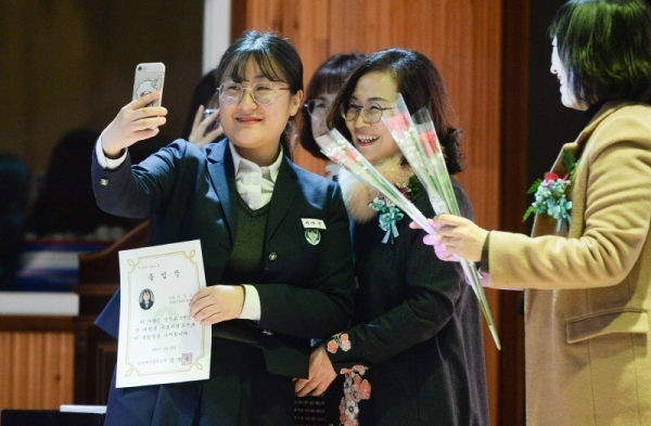30일 2019학년도 졸업식 행사가 열린 인천시 부평구 산곡여중 목련관에서 한 졸업생이 교사들과 함께 마지막 추억을 남기고 있다. 장용준기자