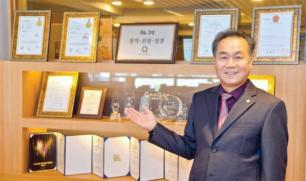 김영기 쿠우쿠우 회장이 그동안 각종 언론사 선정 유망 기업 수상 트로피와 상장들을 소개하고 있다.