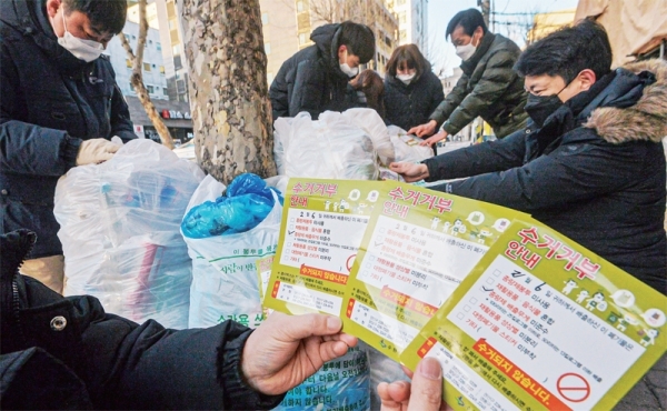 6일 오전 수원시 팔달구 나혜석 거리에서 시 청소자원과 직원들이 종량제 배출무게 상한선 위반 폐기물에 수거 거부 안내문을 붙이고 있다. 수원시가 대용량쓰레기봉투 무게 상한선 도입 등 배출 방법을 명시한 조례를 시행한 지 3개월이 지났으나 여전히 많은 양의 위반 폐기물들이 버려지고 있다. 조주현기자