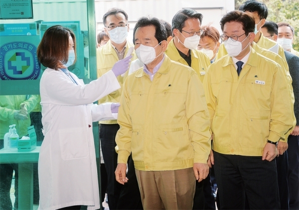 신종 코로나바이러스 감염증 대응 현장점검에 나선 정세균 국무총리와 이재명 경기도지사 등이 8일 오전 경기도의료원 수원병원 음압격리병동을 방문해 현황보고를 받기 전 체온을 재고 있다. 조주현기자
