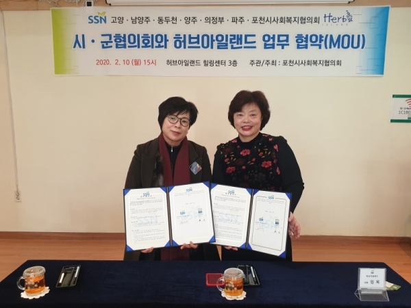 사진설명=한완수 동두천시사회복지협의회장(왼쪽)와 임옥 허브아일랜드 대표가 협약서를 들어 보이고 있다.