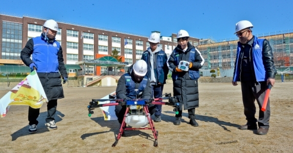 18일 오전 수원 영화초등학교에서 사회적 기업 '사람과 자연 협동조합' 및 수원농생명과학고 내 '더 드론' 동아리 학생들이 방재용 드론을 이용해 수원시 관내 초,중,고교의 코로나19 확산 방지를 위한 방역 활동을 펼치고 있다. 윤원규기자