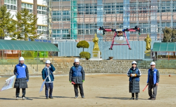 18일 오전 수원 영화초등학교에서 사회적 기업 '사람과 자연 협동조합' 및 수원농생명과학고 내 '더 드론' 동아리 학생들이 방재용 드론을 이용해 수원시 관내 초,중,고교의 코로나19 확산 방지를 위한 방역 활동을 펼치고 있다. 윤원규기자