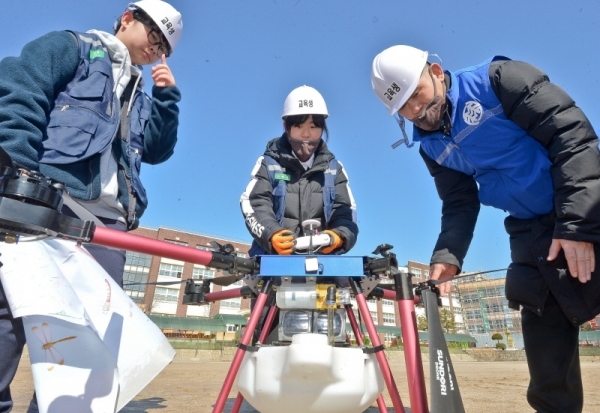 18일 오전 수원 영화초등학교에서 사회적 기업 '사람과 자연 협동조합' 및 수원농생명과학고 내 '더 드론' 동아리 학생들이 방재용 드론을 이용해 수원시 관내 초,중,고교의 코로나19 확산 방지를 위한 방역 활동을 펼치고 있다. 윤원규기자