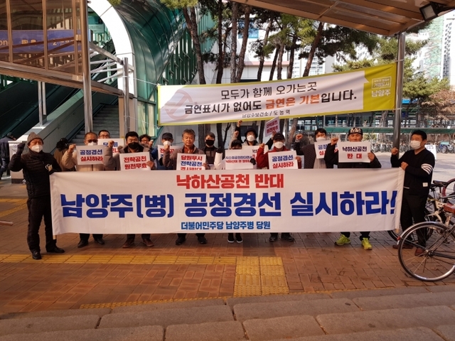 최현덕 예비후보 지지자들이 24일 도농역 앞에서 중앙당 전략 공천 반대시위를 진행하고 있다.
