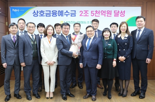26일 농협인천지역본부에서 이태선 남인천농협 조합장(앞줄 왼쪽에서 4번째)과 임동순 인천농협지역본부장(앞줄 왼쪽에서 5번째) 등과 함께 상호금융예수금 2조5천억원 달성탑을 들고 기념촬영을 하고 있다. 농협인천지역본부 제공