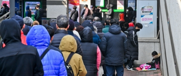 4일 오전 수원시 권선구 하나로마트 수원점에 마스크를 구하기 위한 시민들이 길게 줄을 서 있다. 어린 초등학생이 담요를 덮고 순서를 기다리고 있다. 윤원규기자