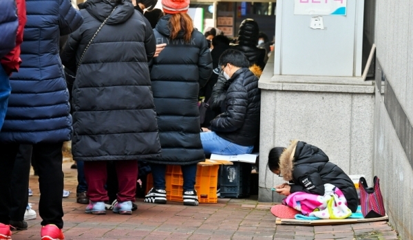 4일 오전 수원시 권선구 하나로마트 수원점에 마스크를 구하기 위한 시민들이 길게 줄을 서 있다. 어린 초등학생이 담요를 덮고 순서를 기다리고 있다. 윤원규기자