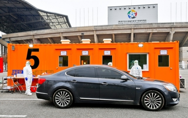 경기도 대규모 코로나19 드라이브 스루 선별진료소가 운영을 시작한 7일 오후 수원시 팔달구 수원월드컵경기장 주차장에서 한 차량에서 시민이 코로나 진단검사를 받고 있다. 경기도는 코로나19 의심환자의 신속한 검사를 위한 대규모 선별검사센터를 수원월드컵경기장 주차장과 경기도청 북부청사 주차장에서 운영한다. 검사 관계자는 031-120으로 사전예약 후 이용하길 당부했다. 윤원규 기자