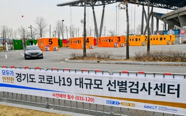 경기도 대규모 코로나19 드라이브 스루 선별진료소가 운영을 시작한 7일 오후 수원시 팔달구 수원월드컵경기장 주차장에서 한 차량에서 시민이 코로나 진단검사를 받고 있다. 경기도는 코로나19 의심환자의 신속한 검사를 위한 대규모 선별검사센터를 수원월드컵경기장 주차장과 경기도청 북부청사 주차장에서 운영한다. 검사 관계자는 031-120으로 사전예약 후 이용하길 당부했다. 윤원규 기자