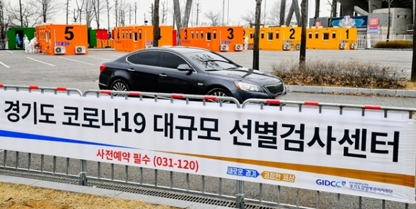 경기도 대규모 코로나19 드라이브 스루 선별진료소가 운영을 시작한 7일 오후 수원시 팔달구 수원월드컵경기장 주차장에서 한 차량에서 시민이 코로나 진단검사를 받고 있다. 경기도는 코로나19 의심환자의 신속한 검사를 위한 대규모 선별검사센터를 수원월드컵경기장 주차장과 경기도청 북부청사 주차장에서 운영한다. 검사 관계자는 031-120으로 사전예약 후 이용하길 당부했다. 윤원규 기자
