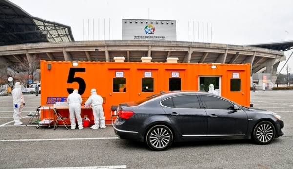 경기도 대규모 코로나19 드라이브 스루 선별진료소가 운영을 시작한 7일 오후 수원시 팔달구 수원월드컵경기장 주차장에서 한 차량에서 시민이 코로나 진단검사를 받고 있다. 경기도는 코로나19 의심환자의 신속한 검사를 위한 대규모 선별검사센터를 수원월드컵경기장 주차장과 경기도청 북부청사 주차장에서 운영한다. 검사 관계자는 031-120으로 사전예약 후 이용하길 당부했다. 윤원규 기자